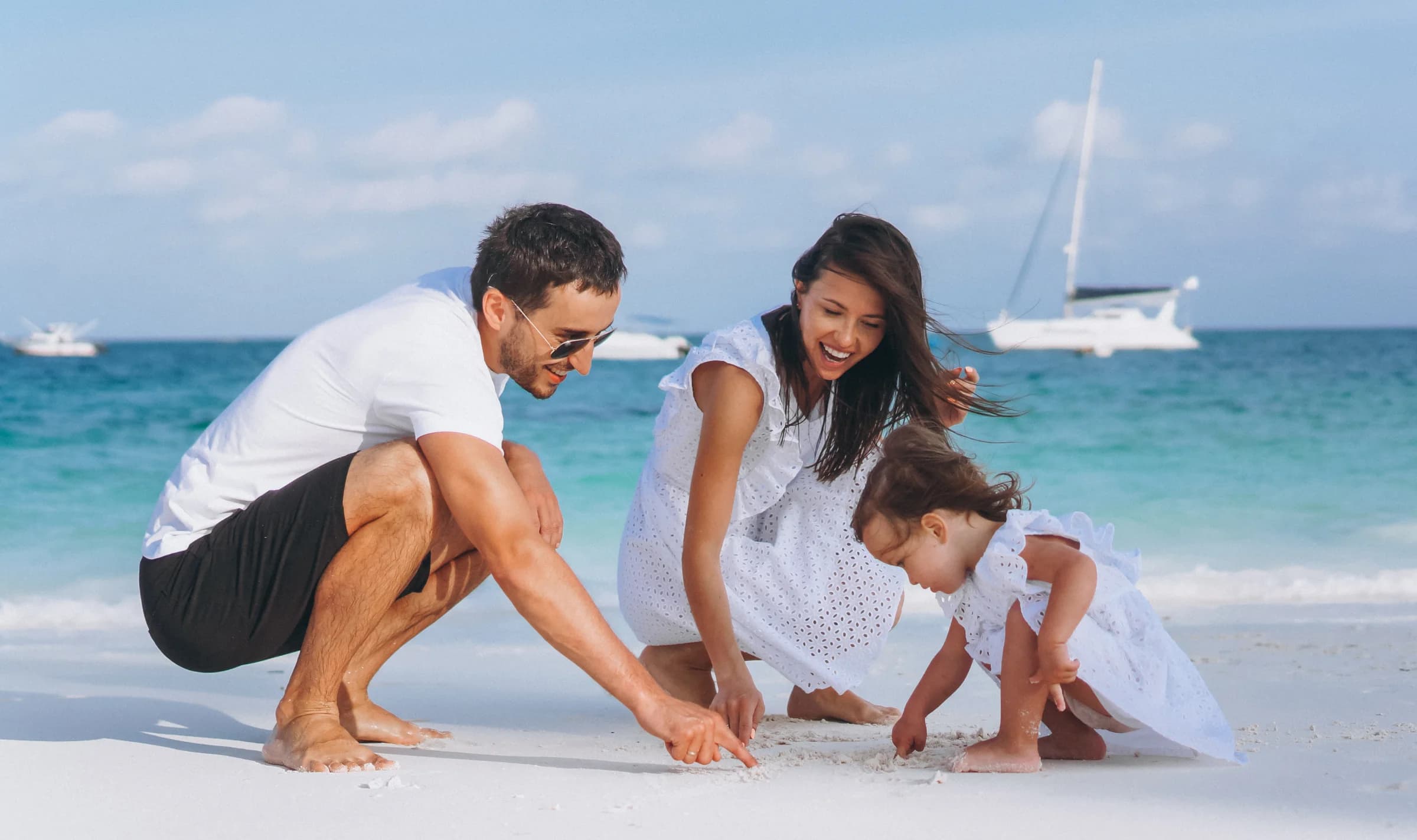Família brincando na areia perto do mar